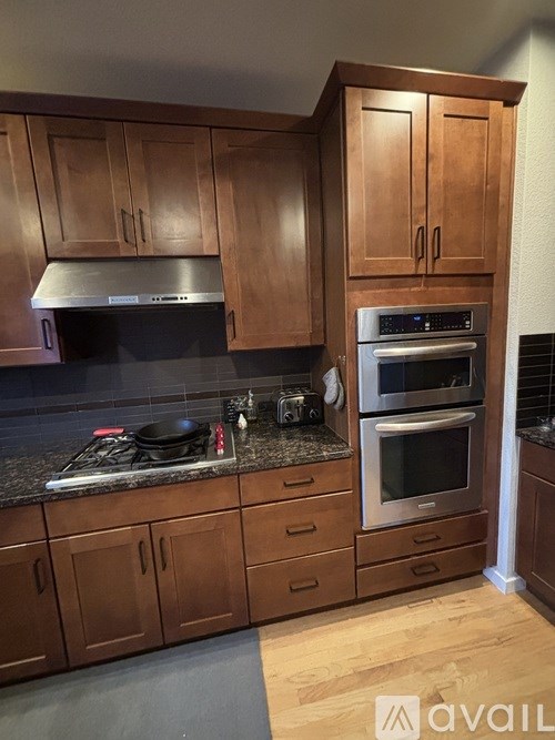 A kitchen with wooden cabinets and a stainless steel oven.