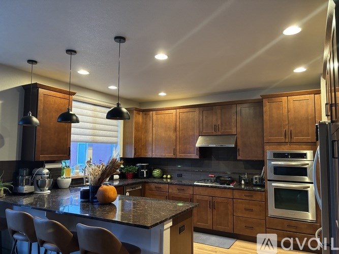A kitchen with wooden cabinets and a granite countertop.