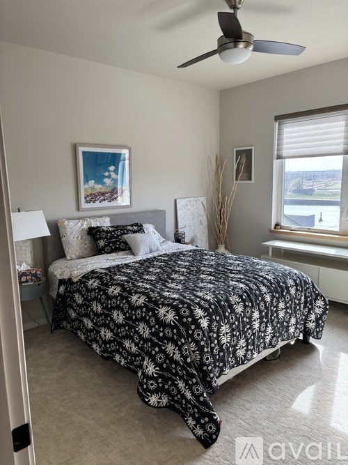A bedroom with a large bed and a ceiling fan.