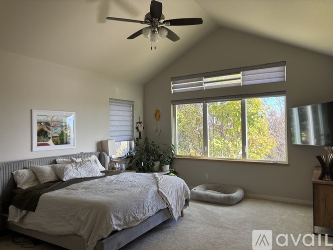 A bedroom with a large bed and a ceiling fan.