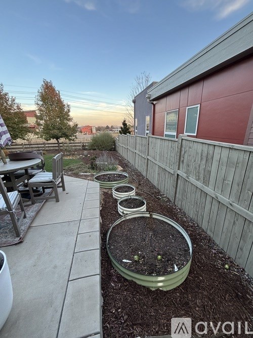 A backyard with a wooden fence and a patio table.