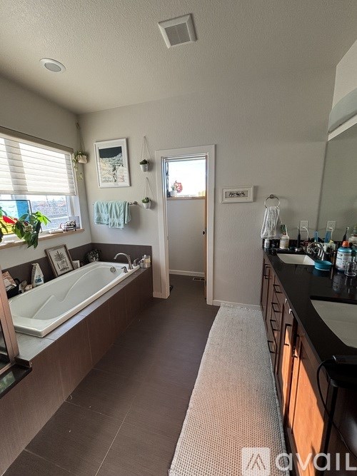 A bathroom with a tub, sink, and mirror.