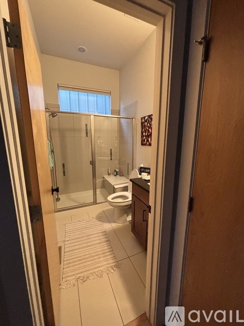 A bathroom with a toilet, sink and shower.