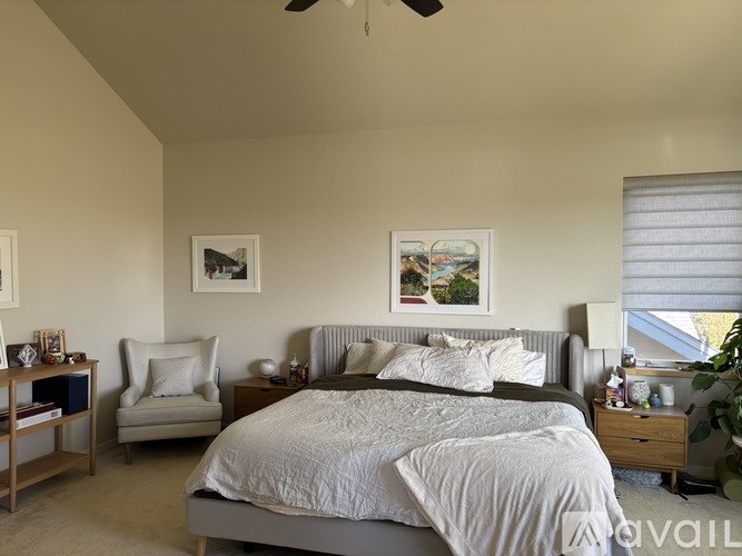 A bedroom with a large bed and a ceiling fan.