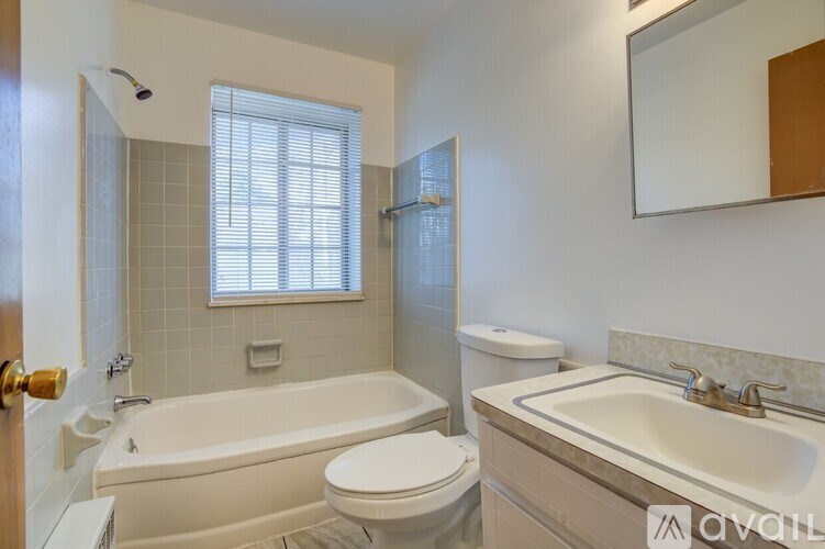 A bathroom with a white tub, toilet, and sink.
