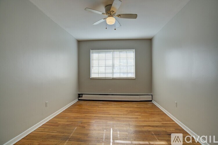 A room with a ceiling fan and a window.