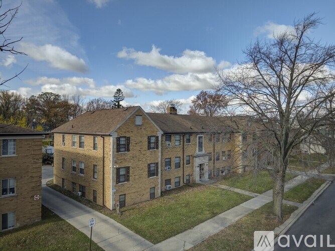 A large brick building with a tree in front of it.