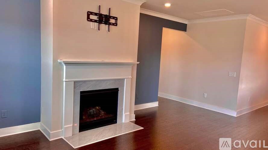 A living room with a fireplace and a wall hanging.