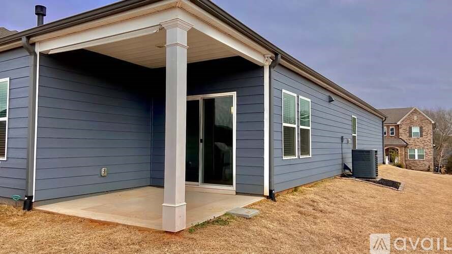 A blue house with a covered patio area.