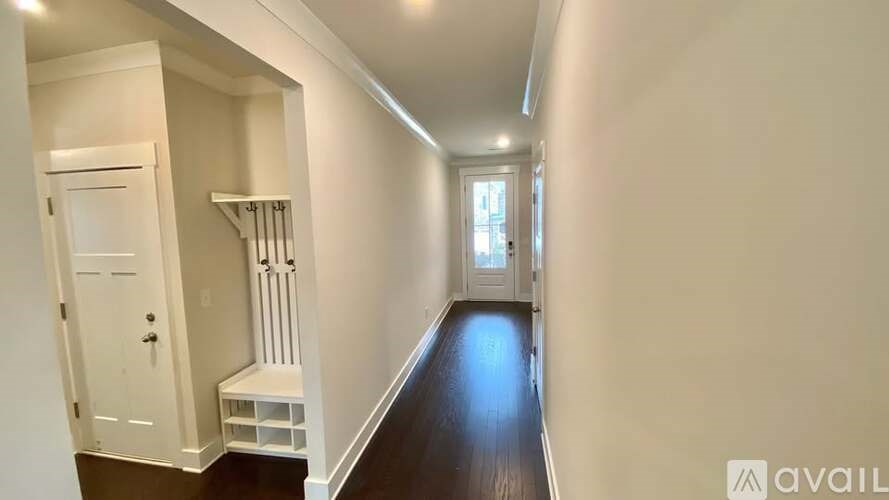 A hallway with a white door and a window.