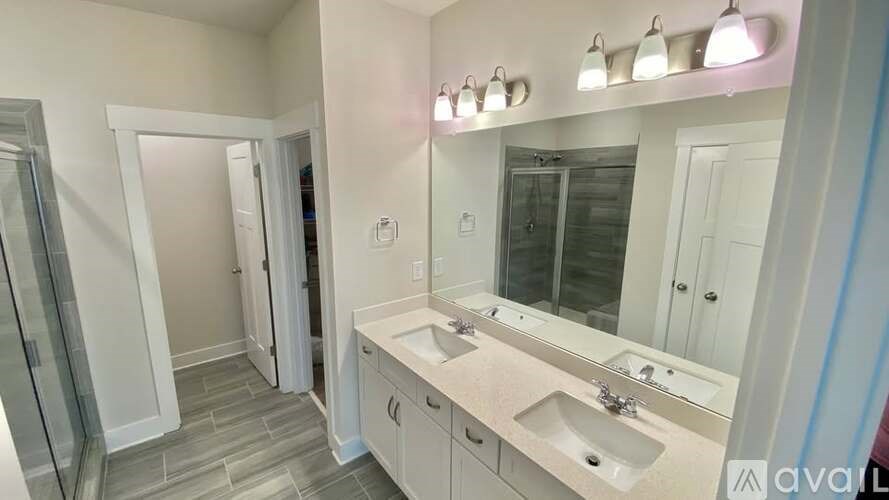 A bathroom with a sink, mirror, and a glass door shower.