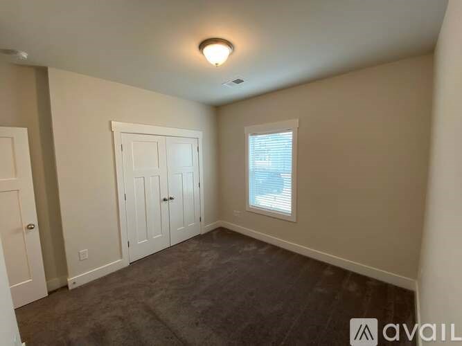 A room with a window and a door is available for rent.