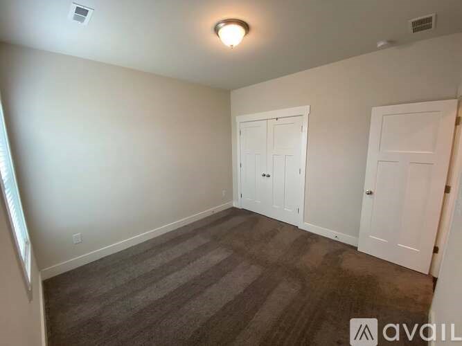 A room with two doors and carpeted floor.