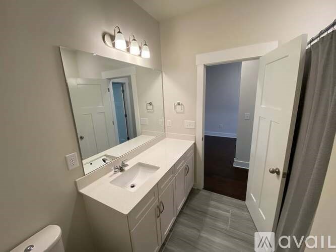 A bathroom with a sink, mirror, and toilet.
