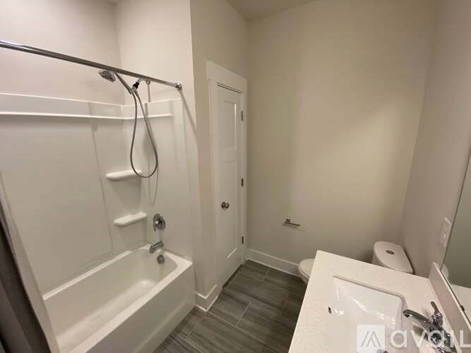 A white bathroom with a tub, toilet, and sink.