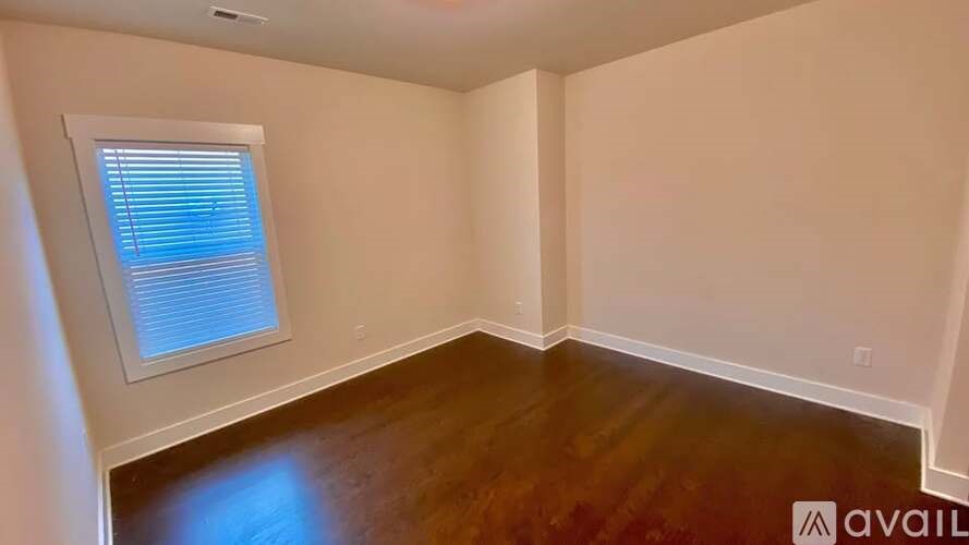 A room with a window and wooden flooring is available for rent.