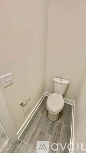 A white toilet in a small bathroom with a grey floor.