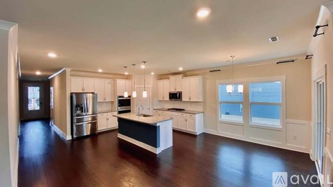 A spacious kitchen with white cabinets and a central island.