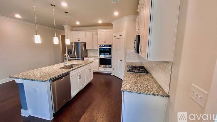 A modern kitchen with white cabinets and a granite countertop.