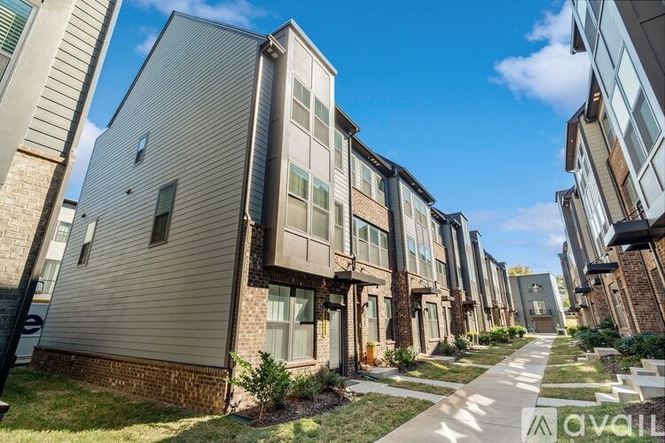 A row of modern townhouses with a clear blue sky above them.