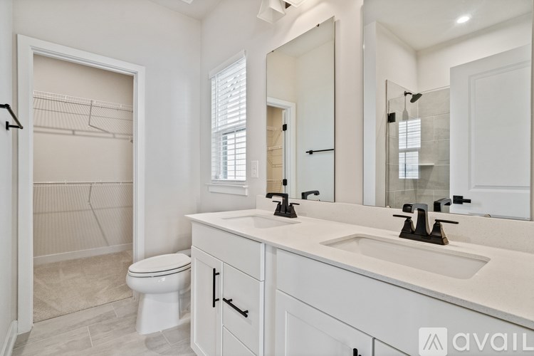 A bathroom with a toilet, sink, and mirror.