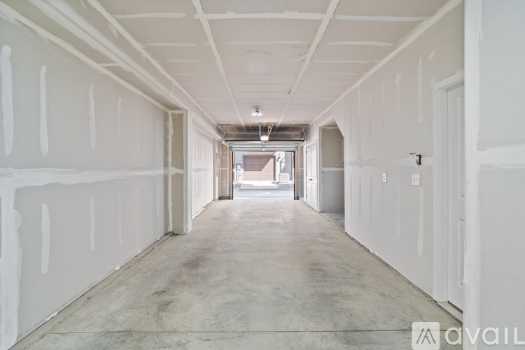 A long, empty hallway with white walls and a concrete floor.