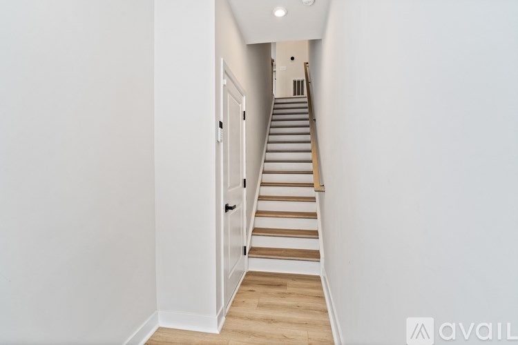 A long staircase with wooden steps and a white door.