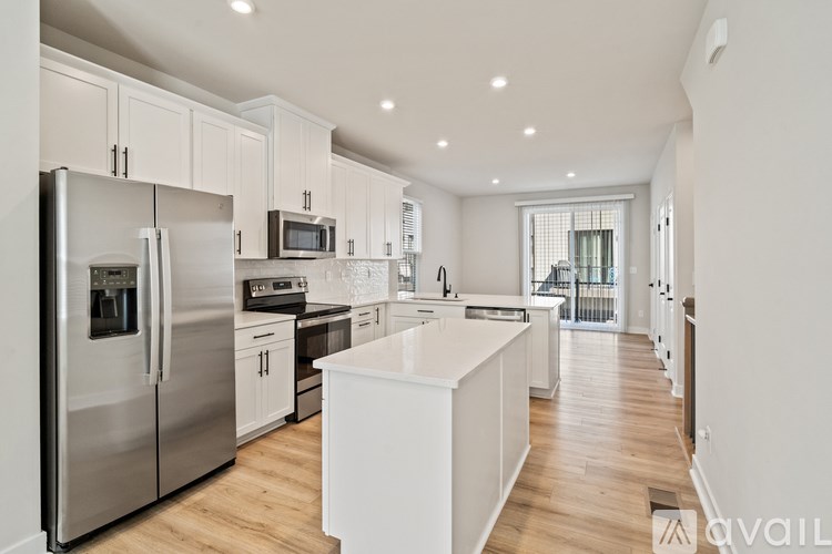 A modern kitchen with a refrigerator, microwave, oven, and sink.