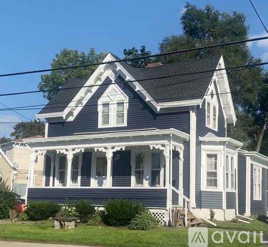 A blue house with white trim and a large front porch.