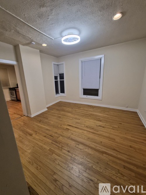 A room with wooden flooring and a window.