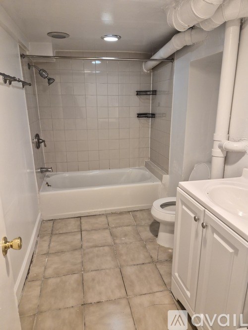 A white bathroom with a toilet, sink, and bathtub.