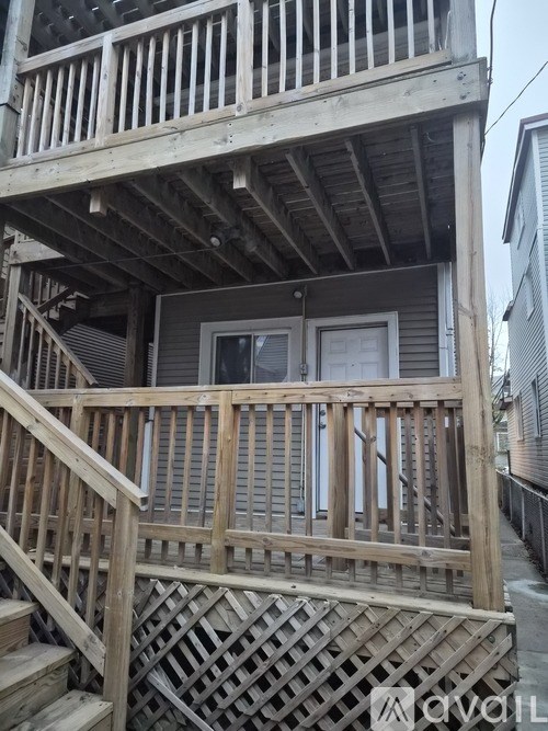 A wooden deck with a lattice patterned railing.