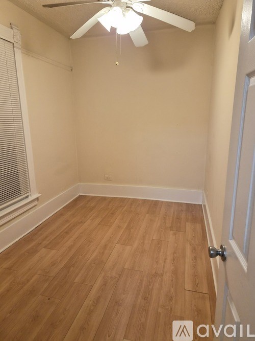 A room with wooden flooring and a ceiling fan.