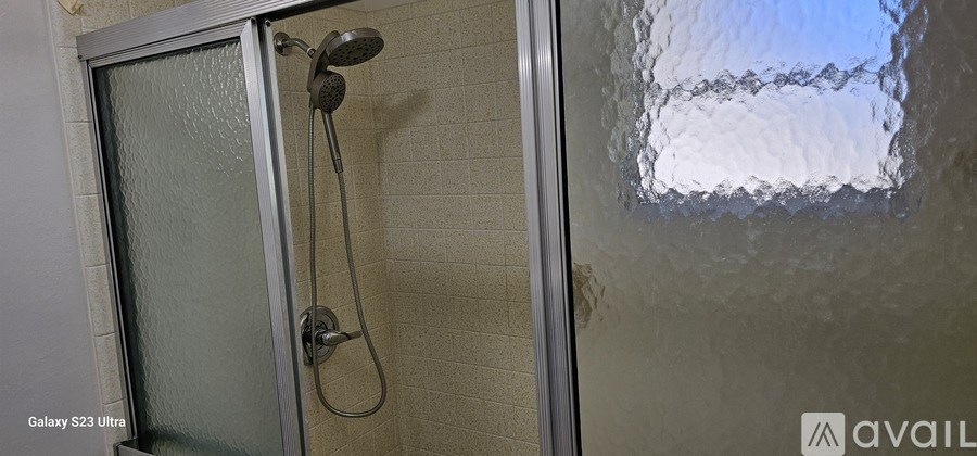 A shower stall with a glass door and a shower head.