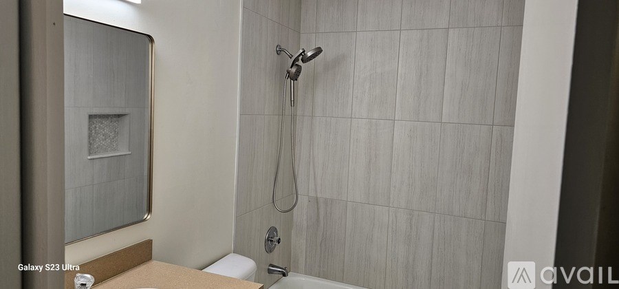 A bathroom with a shower and a mirror.