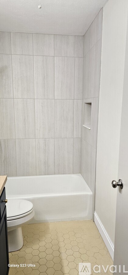 A bathroom with a white toilet and a white bathtub.