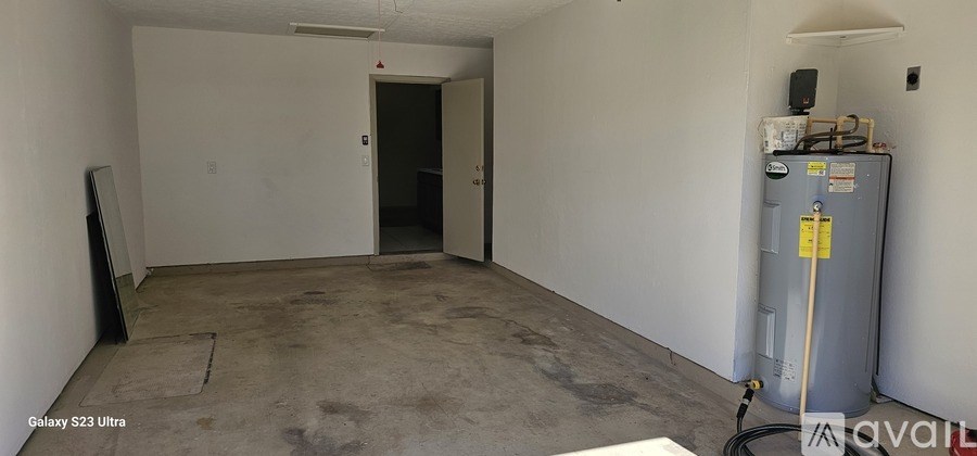A room with a Samsung TV on the left and a water heater on the right.