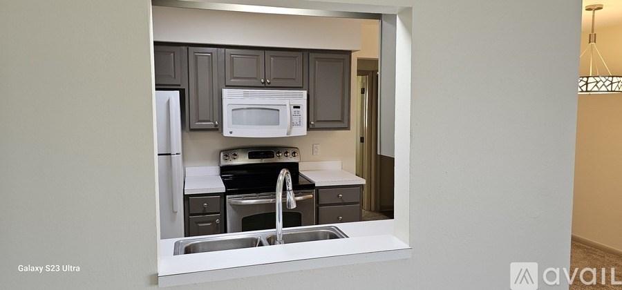 A kitchen with a white fridge and microwave.