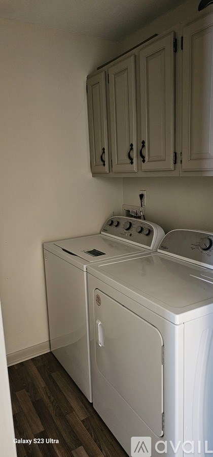 A white washing machine and dryer in a laundry room.