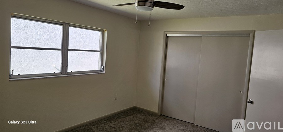 A room with a ceiling fan and a door.