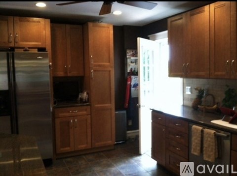 A kitchen with wooden cabinets and a stainless steel refrigerator.