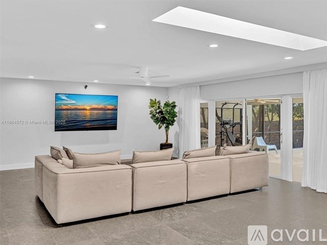 A large beige sofa in a spacious room with a painting on the wall.