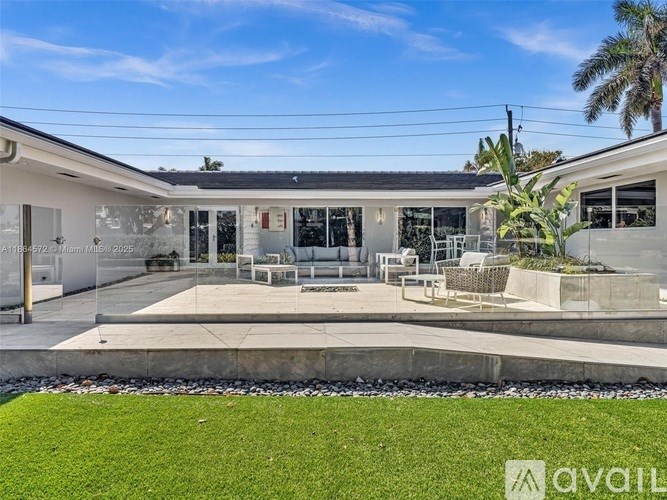 A modern house with a glass wall and a patio area.