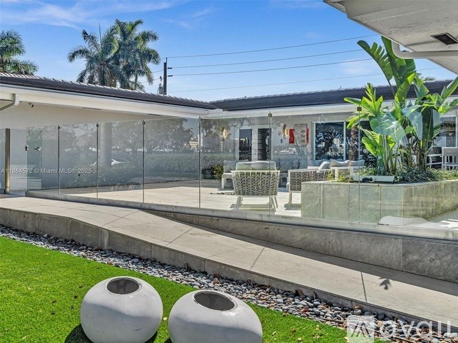 A patio area with a glass wall and two large white vases.