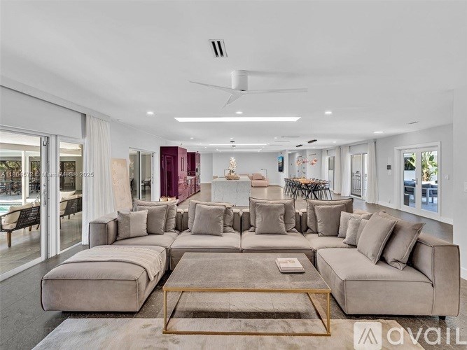 A spacious living room with a large sectional sofa and a coffee table in the center.