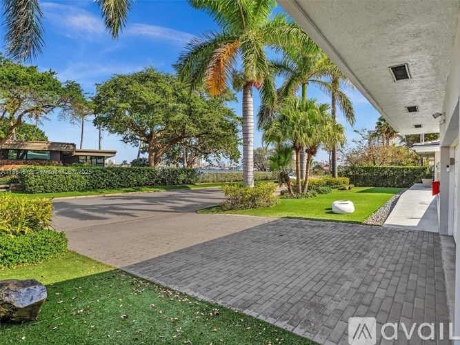 A driveway leads to a house with a palm tree in the yard.