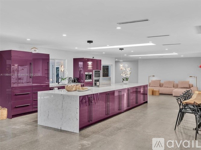 A modern kitchen with purple cabinets and a white island.
