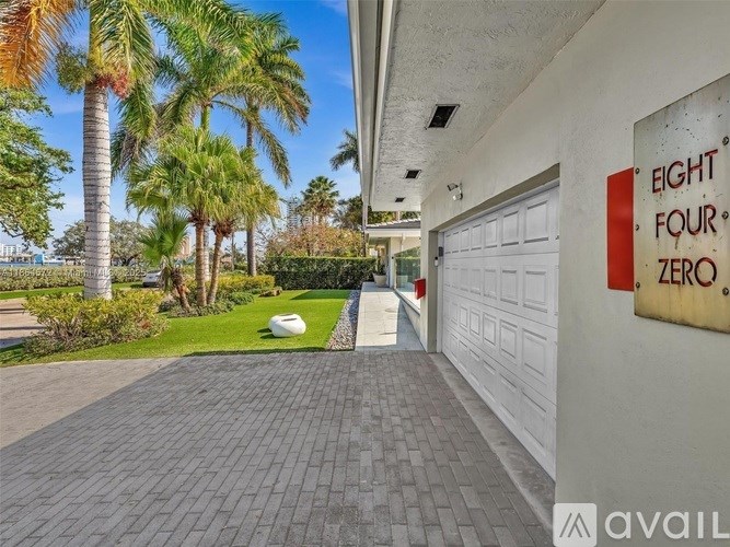 A driveway leads to a garage with a sign that reads "Eight Four Zero.".