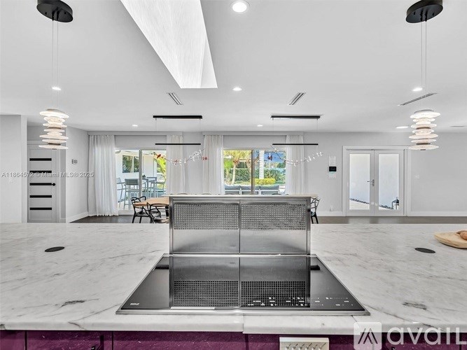 A modern kitchen with a marble countertop and a stainless steel sink.