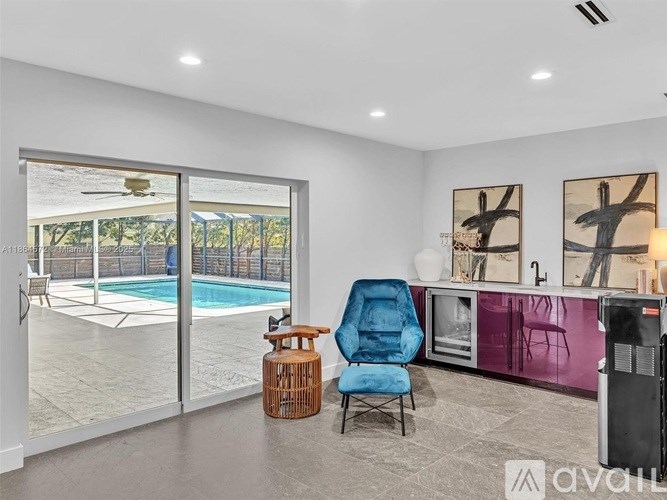 A living room with a blue chair and a purple cabinet.